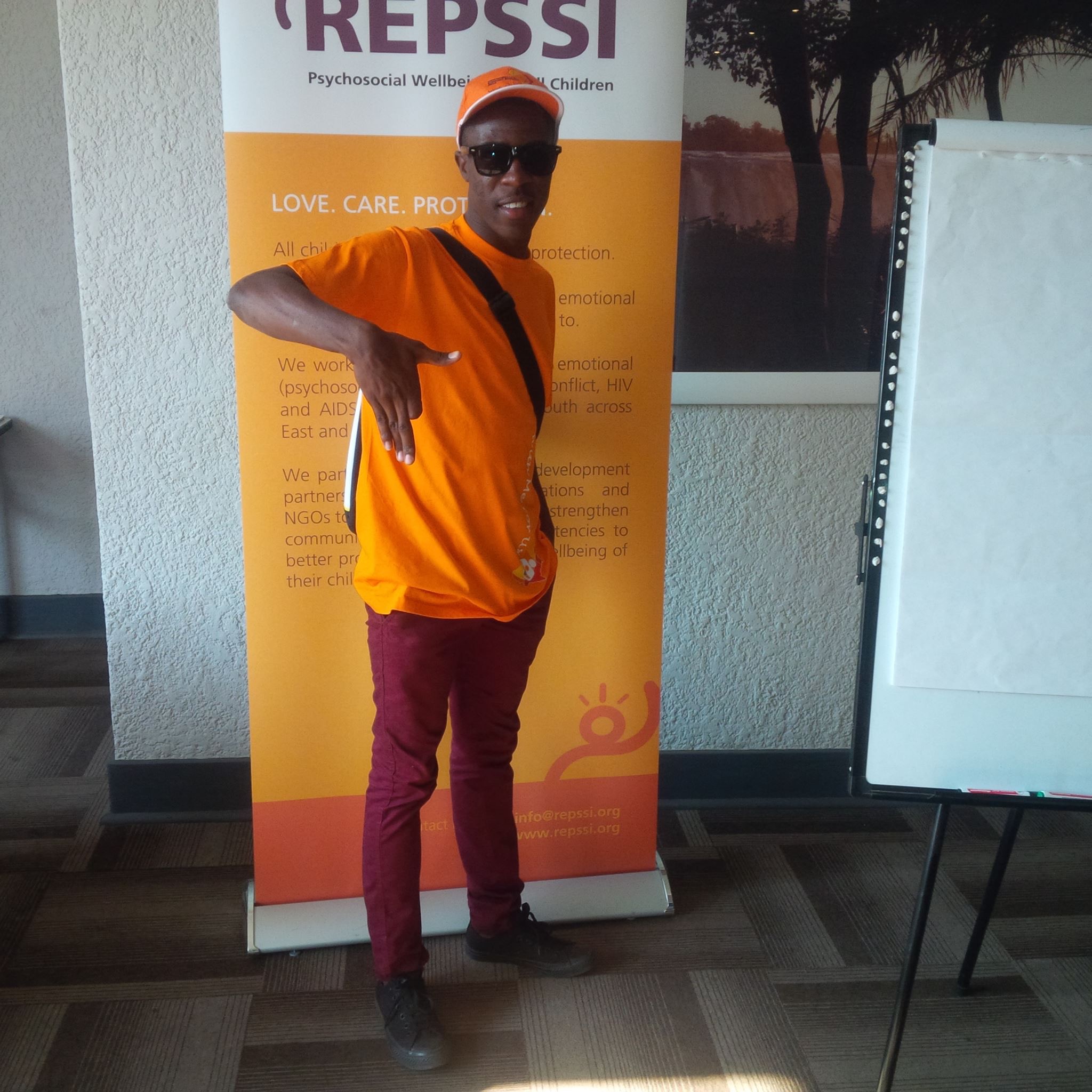 Jastes shows his Namibian pride in front of the conference banner, Victoria Falls, Zimbabwe.